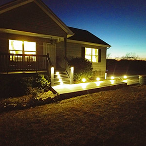 The front porch of Cottage 37 at Edgewater in Taylorsville all lit up by exterior lights